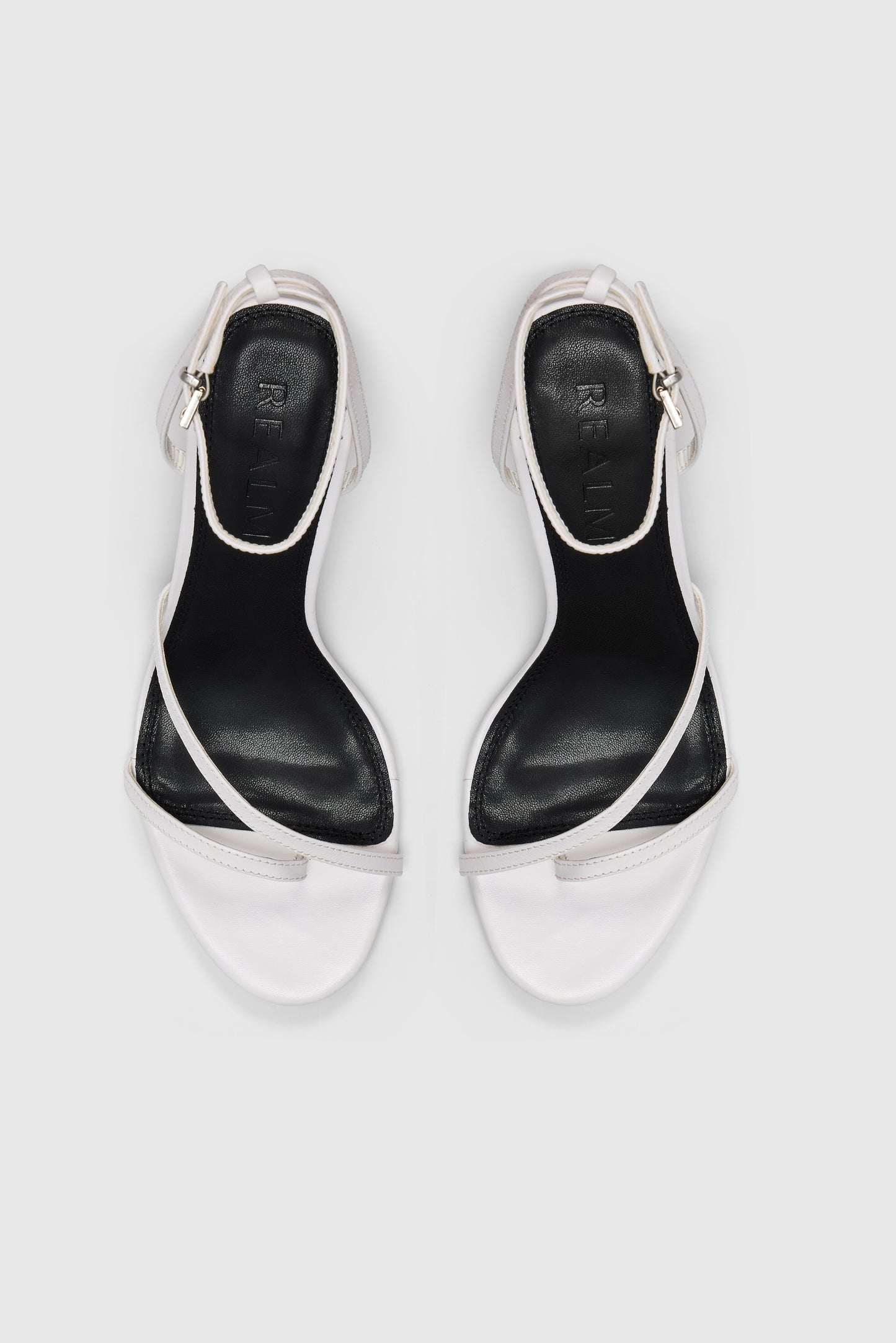 White leather asymmetric heeled sandals with an ankle strap