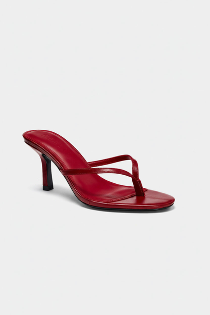 The Spirit Heeled Sandals in red leather by Realm feature thin straps, a toe post, a square open toe, and a slim stiletto heel.