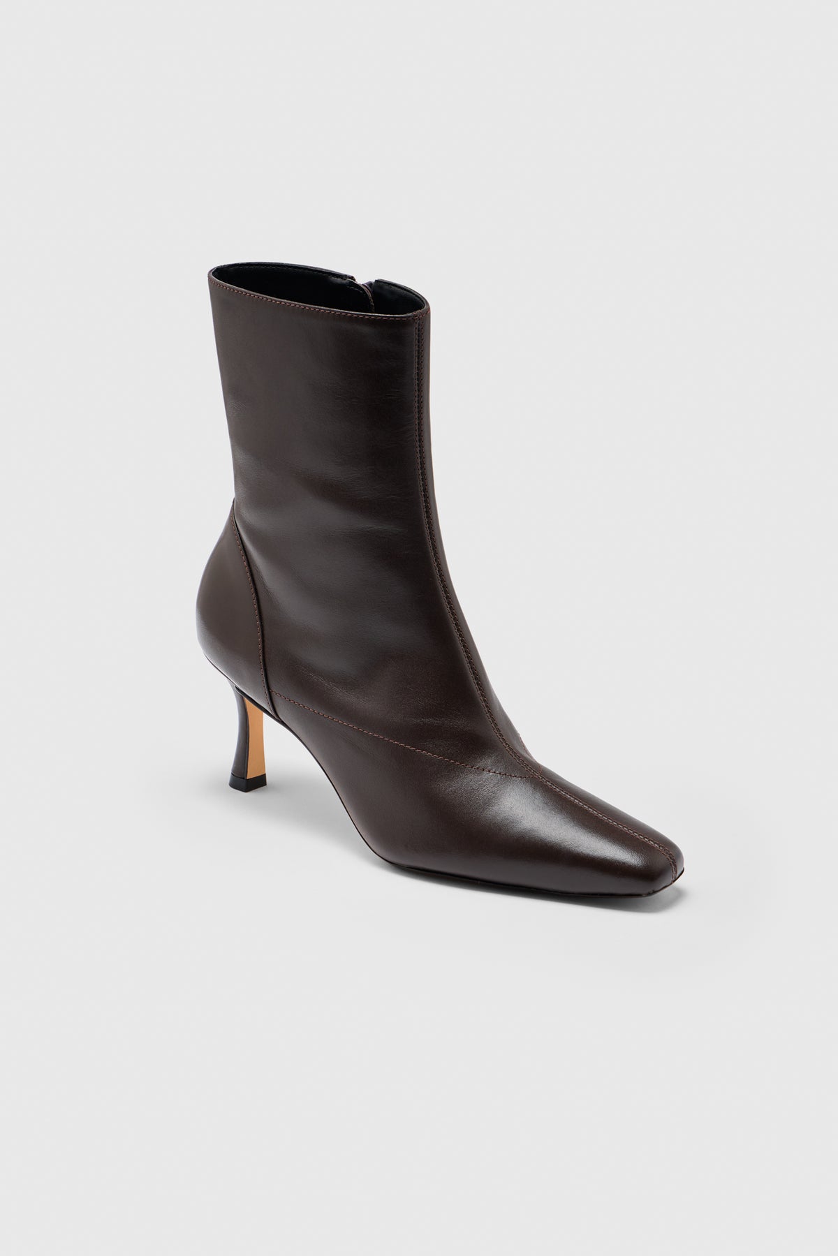 The Realm Encore Ankle Boot is crafted from black leather with a pointed toe and a low, slim heel, showcased against a plain light grey background—an effortlessly versatile addition to any capsule wardrobe.