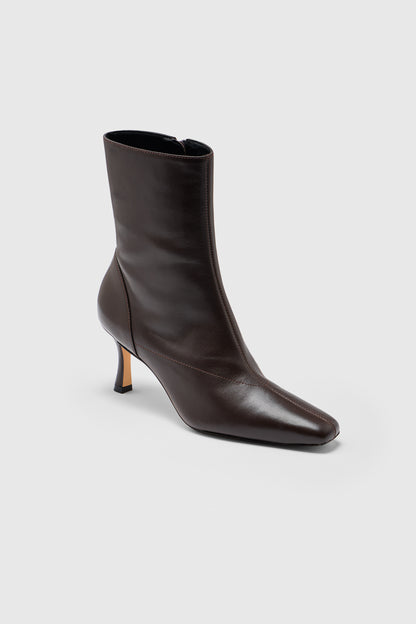 The Realm Encore Ankle Boot is crafted from black leather with a pointed toe and a low, slim heel, showcased against a plain light grey background—an effortlessly versatile addition to any capsule wardrobe.