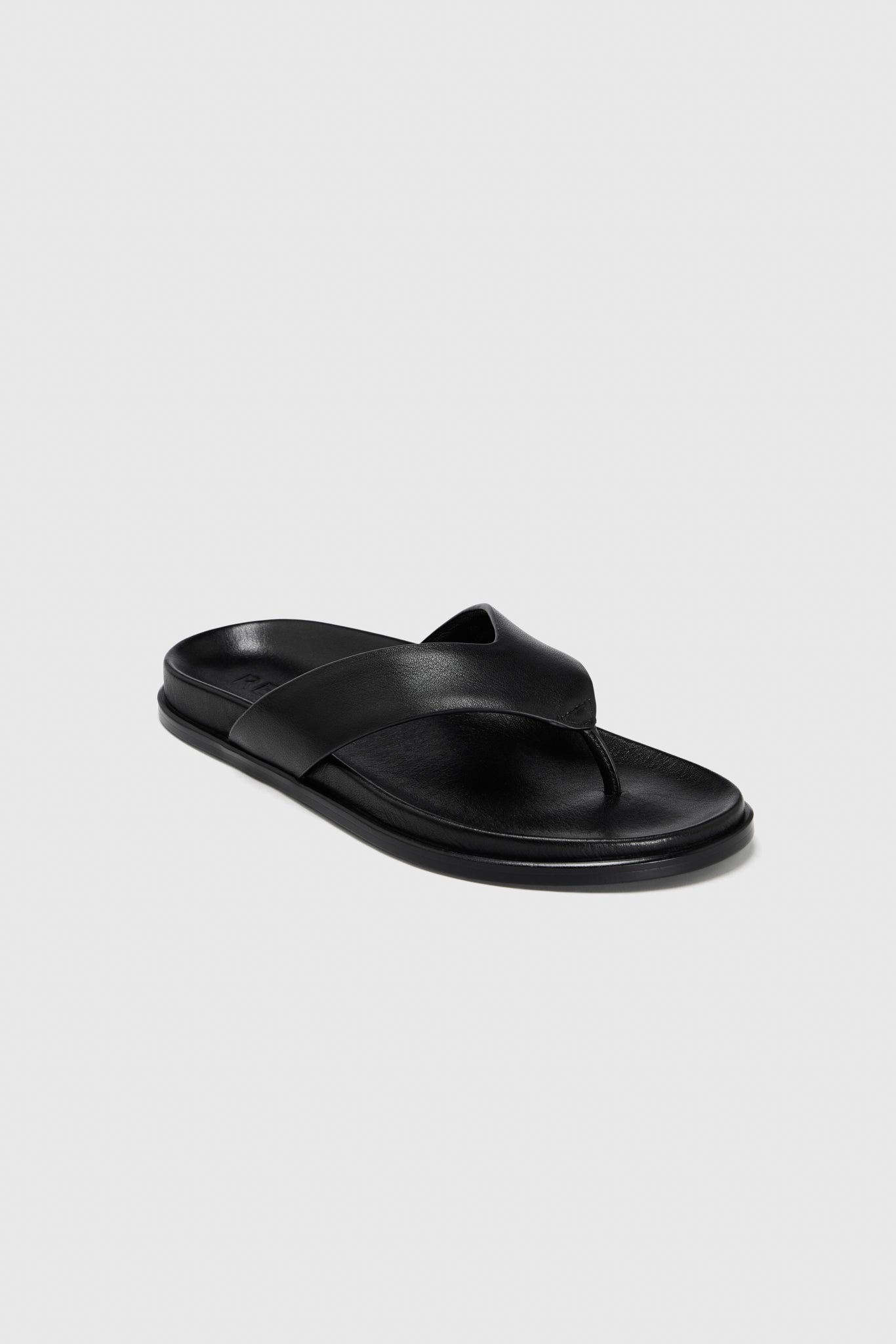 A single black leather flip-flop with a wide leather strap, toe post, and contoured footbed, shown on a plain light gray background.