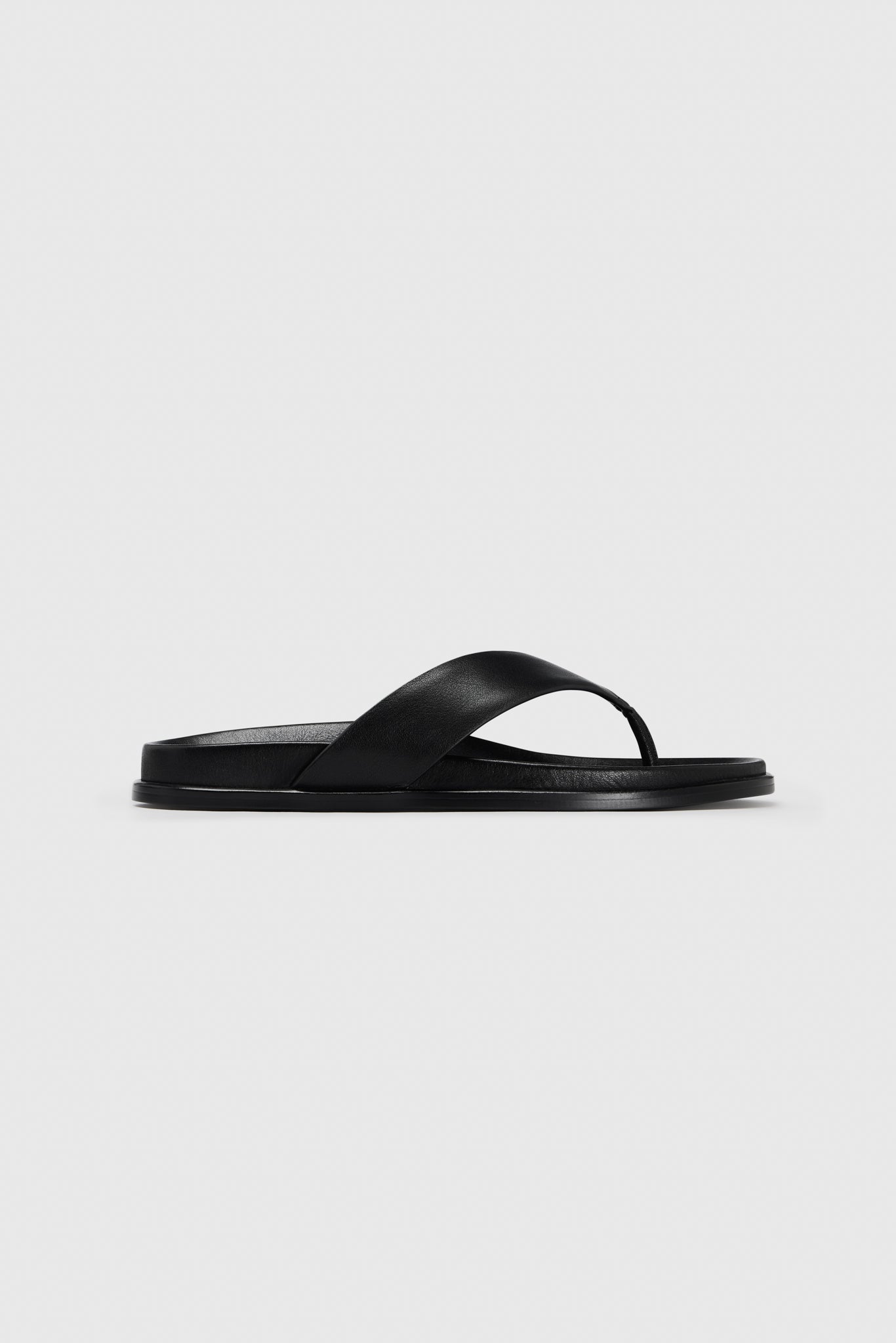 The black leather Realm Contour Flats feature a wide crisscross strap, contoured footbed, and flat sole on a plain white background.