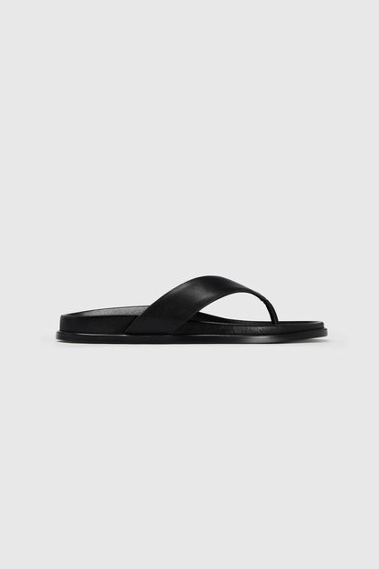 The black leather Realm Contour Flats feature a wide crisscross strap, contoured footbed, and flat sole on a plain white background.