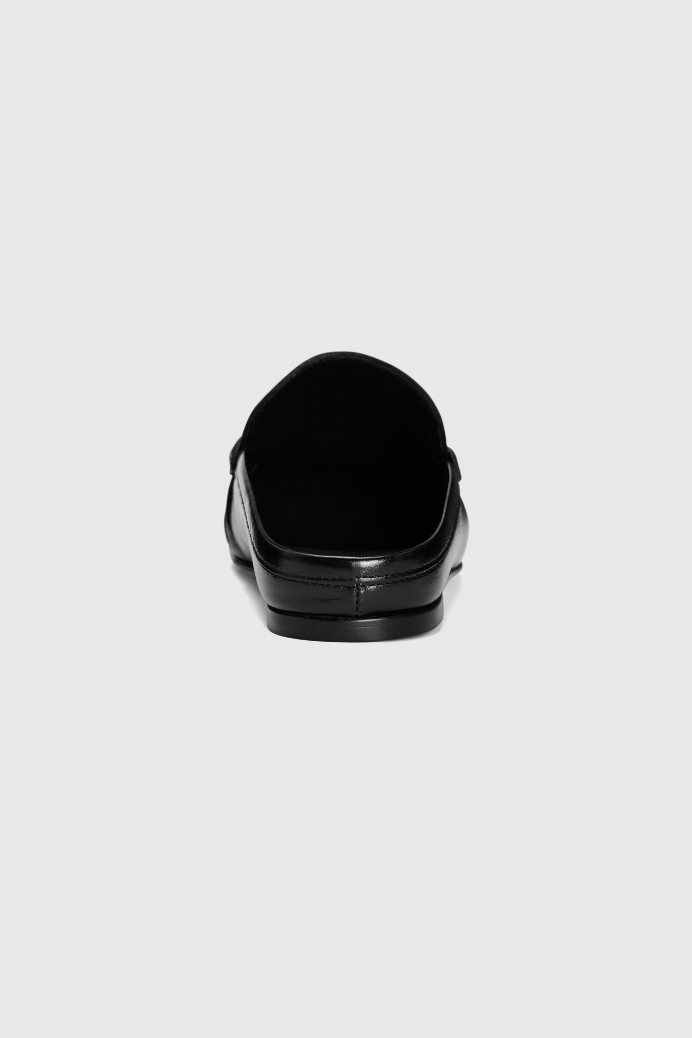 The Realm Everyday Loafers in black leather are slip-on shoes, shown from the back against a plain light gray background.