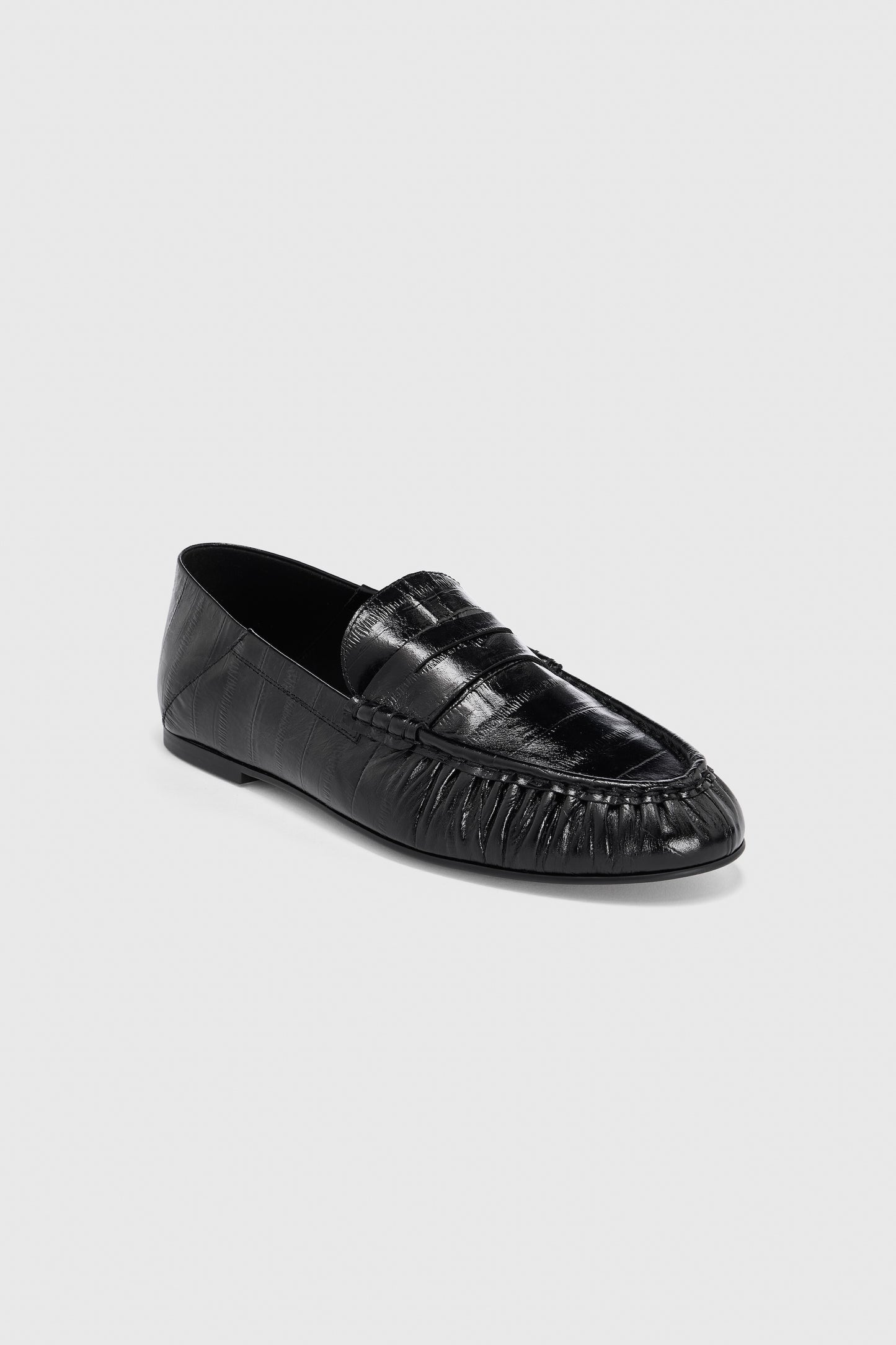 A pair of Realm Form Loafers | Gloss Black Leather in black embossed leather, featuring a moccasin-style toe, penny loafer strap, and subtle stitching details, displayed on a light gray background.