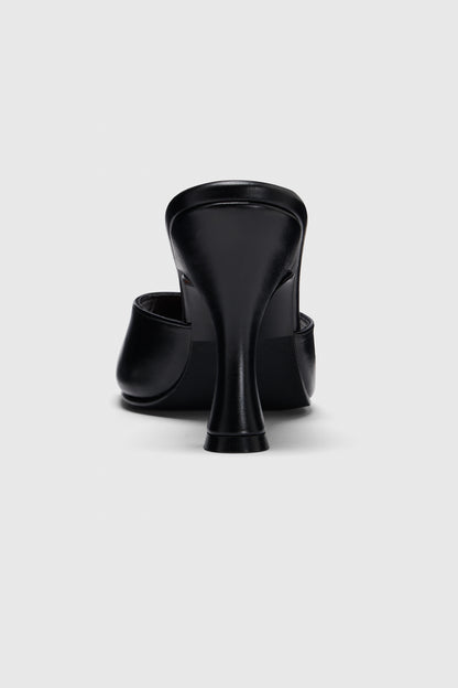 Rear view of black leather mules by Realm, showing their curved heel and closed toe, set against a light gray background.