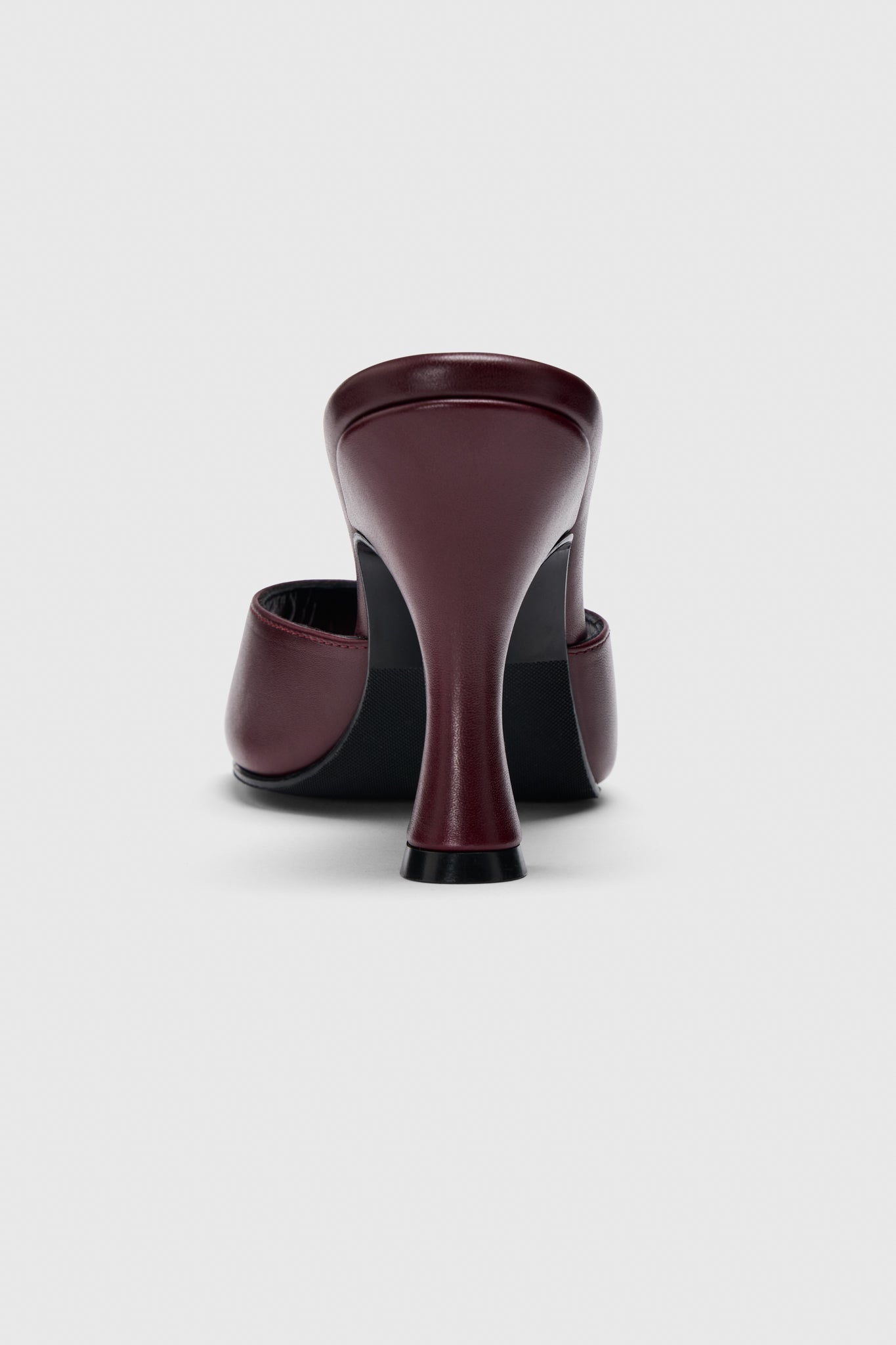 Back view of Realm’s The Mules in burgundy leather—single slip-on mule with flared heel, shown against a plain light gray background.